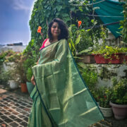 Shimmer-finish green saree in garden setting