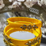 Yellow kundan bangles wrapped in silk thread