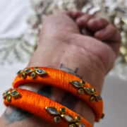 Handcrafted kundan bangles wrapped in orange silk thread