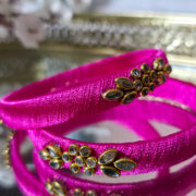 Bright pink silk thread bangles decorated with kundan and stones