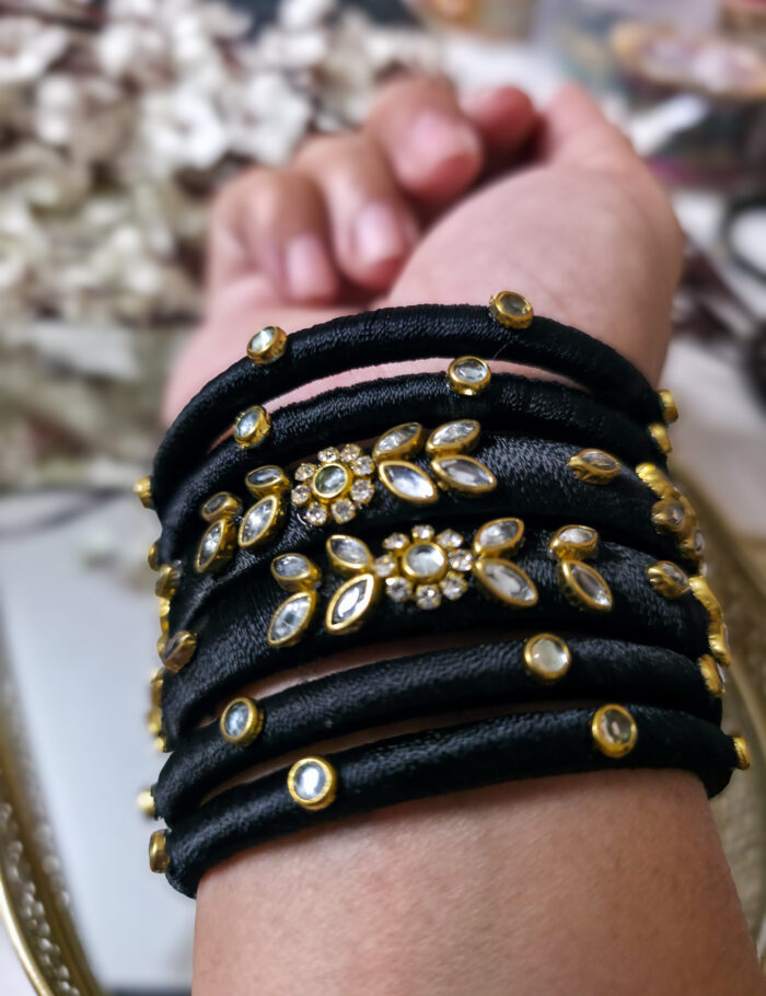 Handcrafted kundan bangles wrapped in black silk thread
