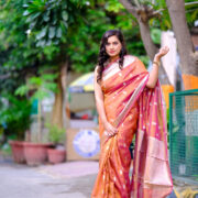 A rich Banarasi silk saree with gold zari border draped artfully.